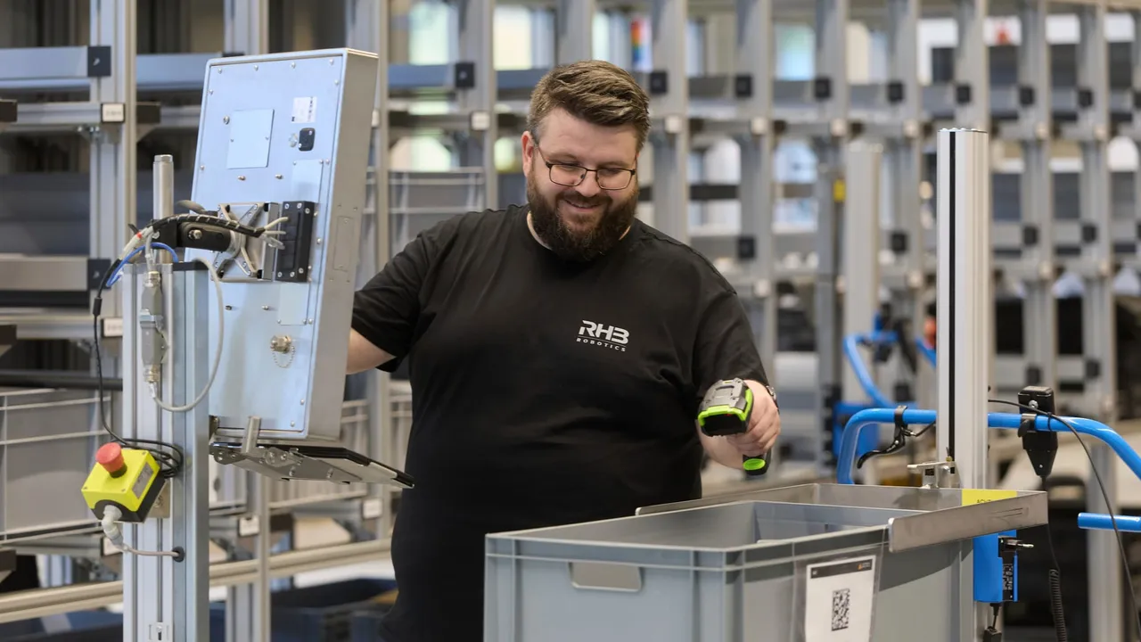Mitarbeiter erfasst einen Behälter mit dem Handscanner an der Materialbereitstellung