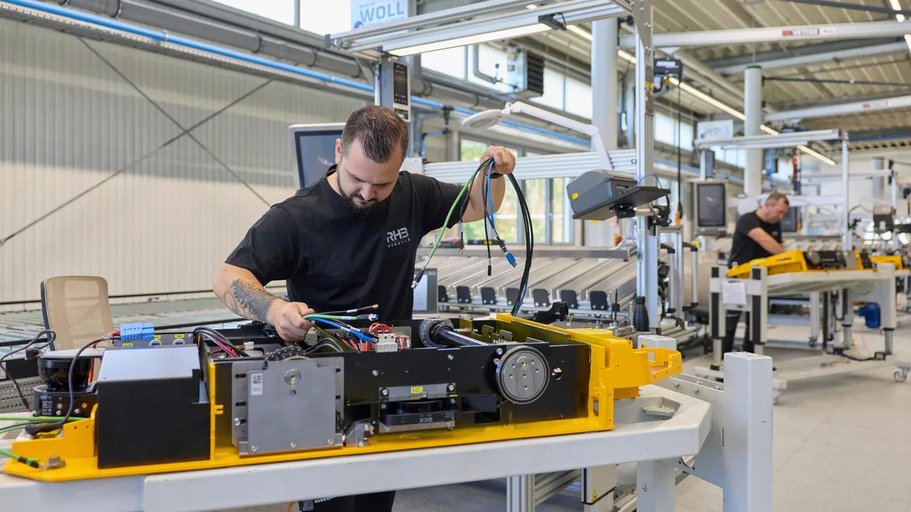 Mitarbeiter verlegt Leitungen im geöffneten Chassis