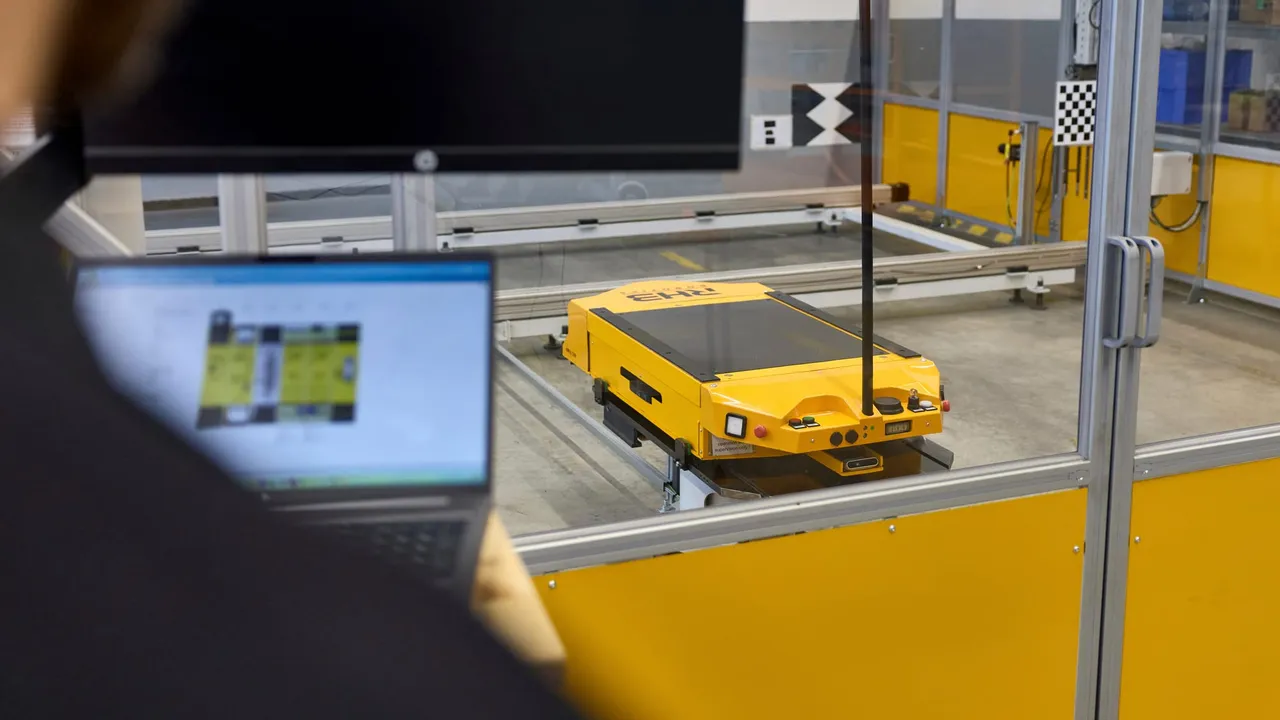 Fahrzeug auf dem Prüfstand, daneben der Arbeitsplatz mit Laptop