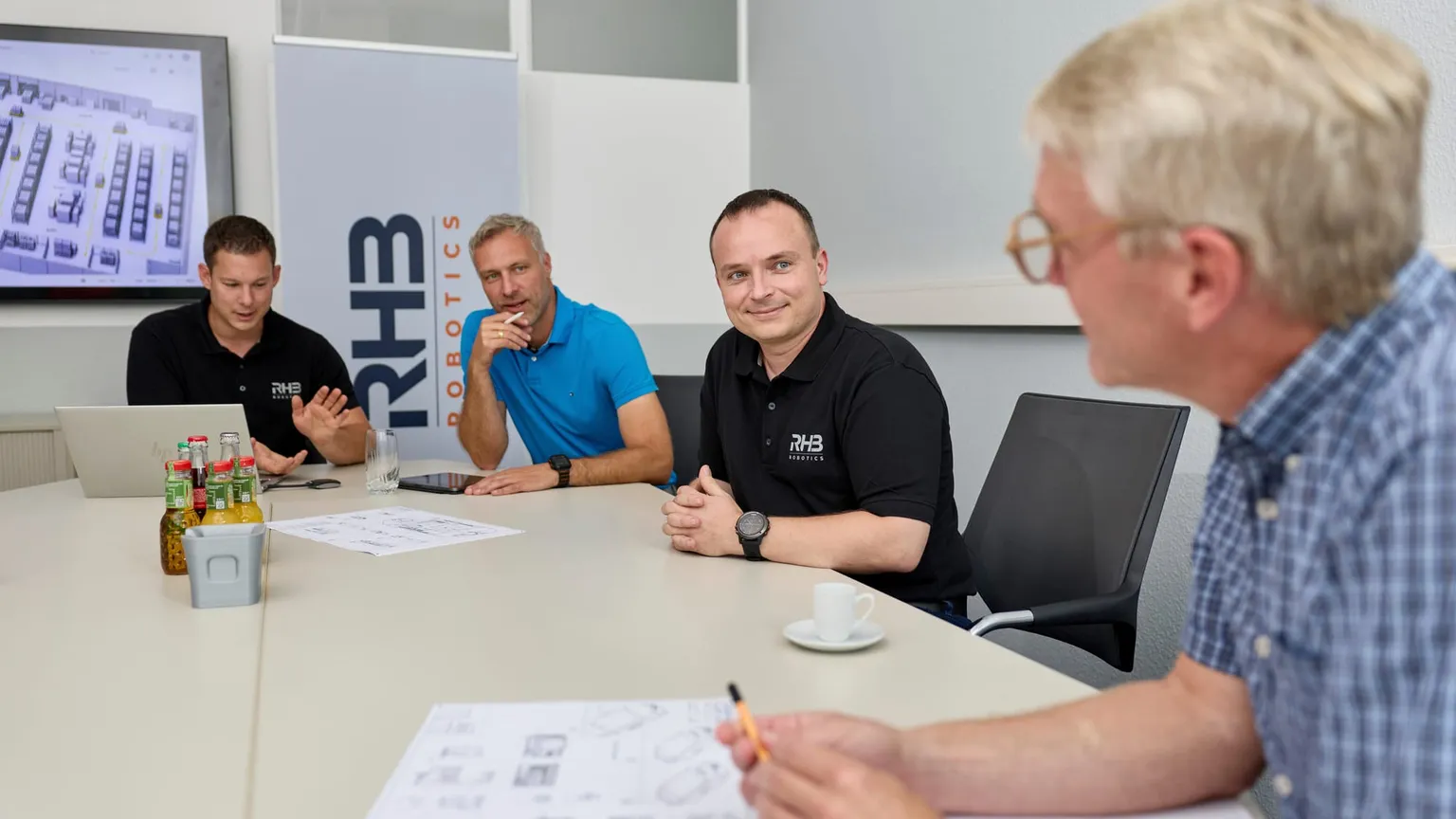 Konzeptbesprechung am Tisch, Layout und Zeichnungen zwischen den Beteiligten