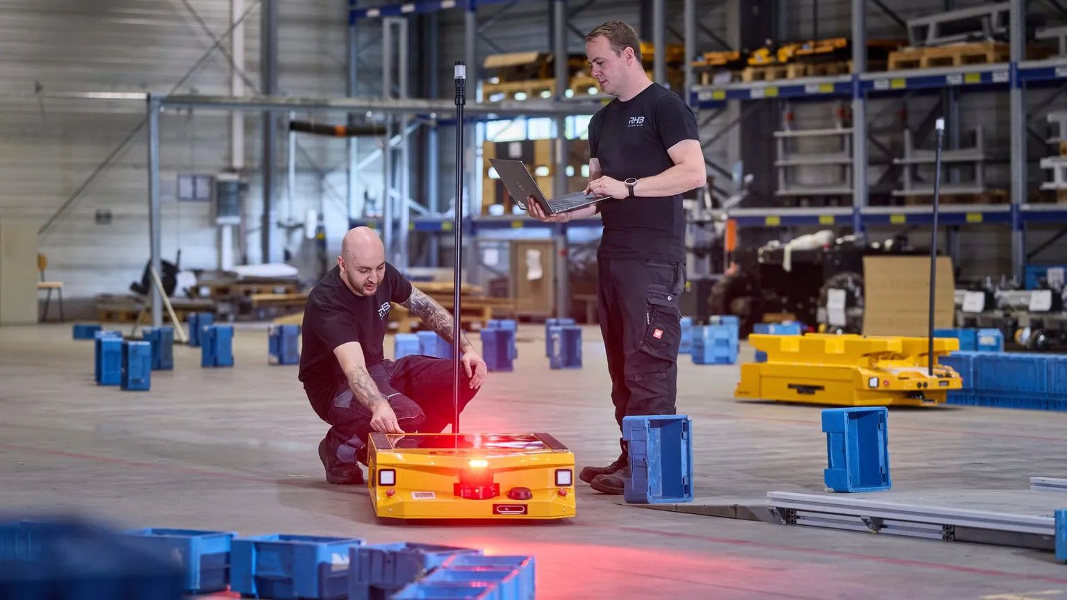 Einlernen des Fahrzeugs, zwei Techniker mit Laptop an der Referenzstrecke